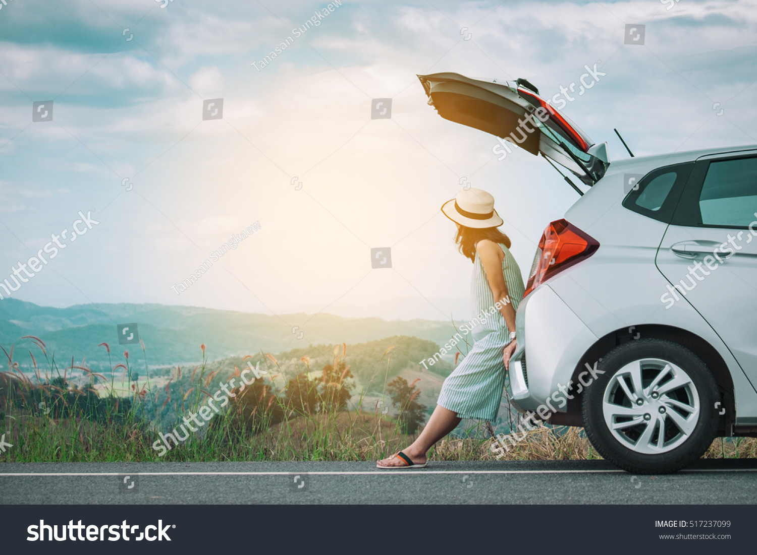 Woman traveler sitting on hatchback car with mountain background in vintage tone #517237099