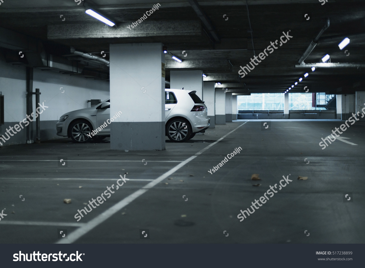 White car parked in empty parking garage. #517238899