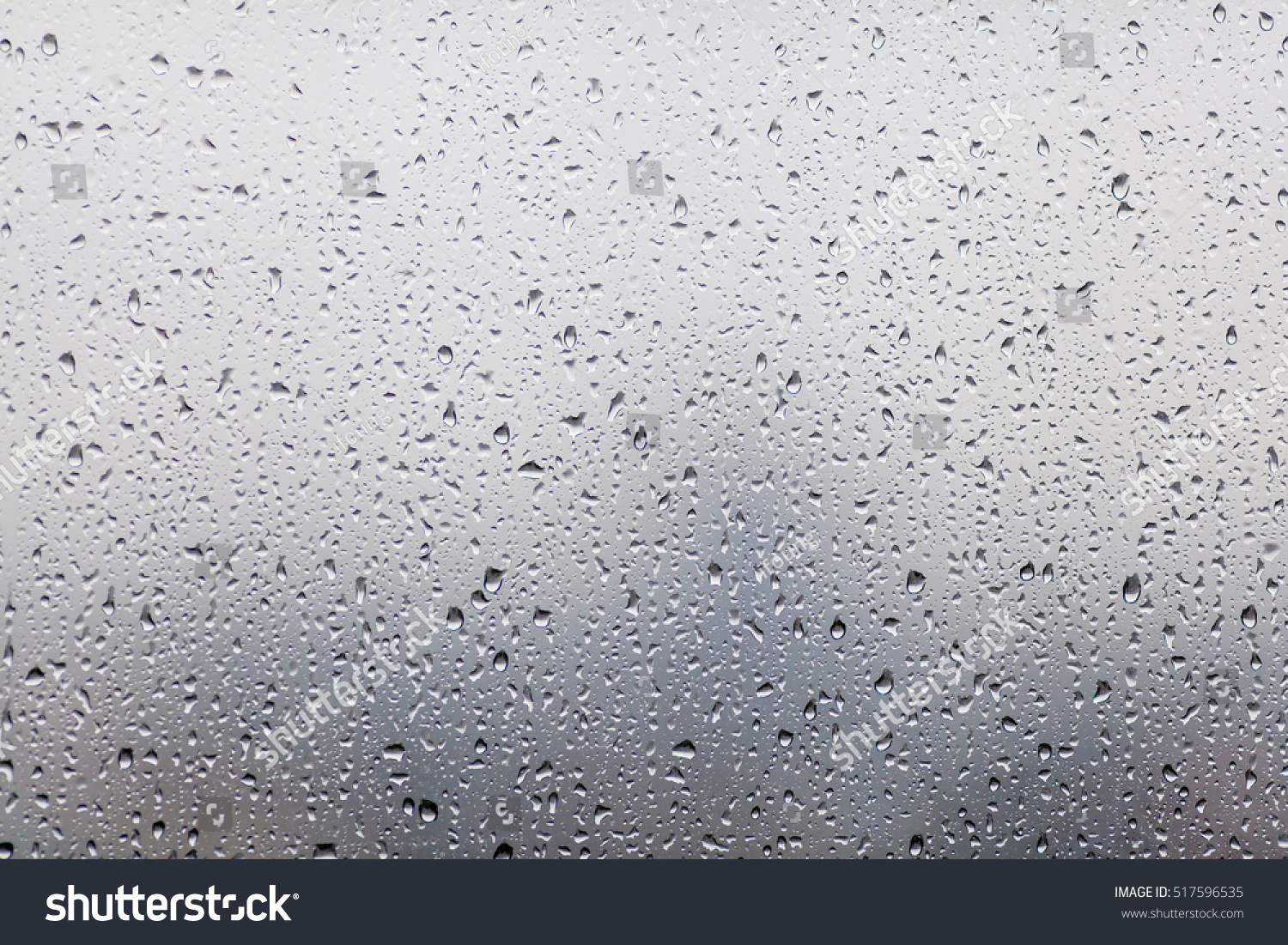 Raindrops on glasses surface. Natural Pattern of rain drops isolated on cloudy background. #517596535