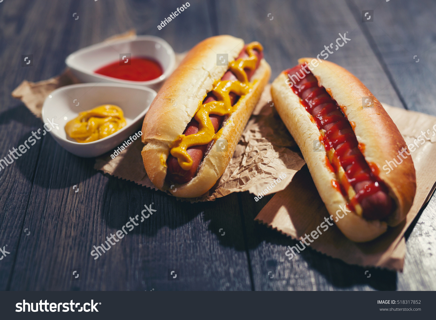 Tasty hot dogs on paper on wooden background #518317852