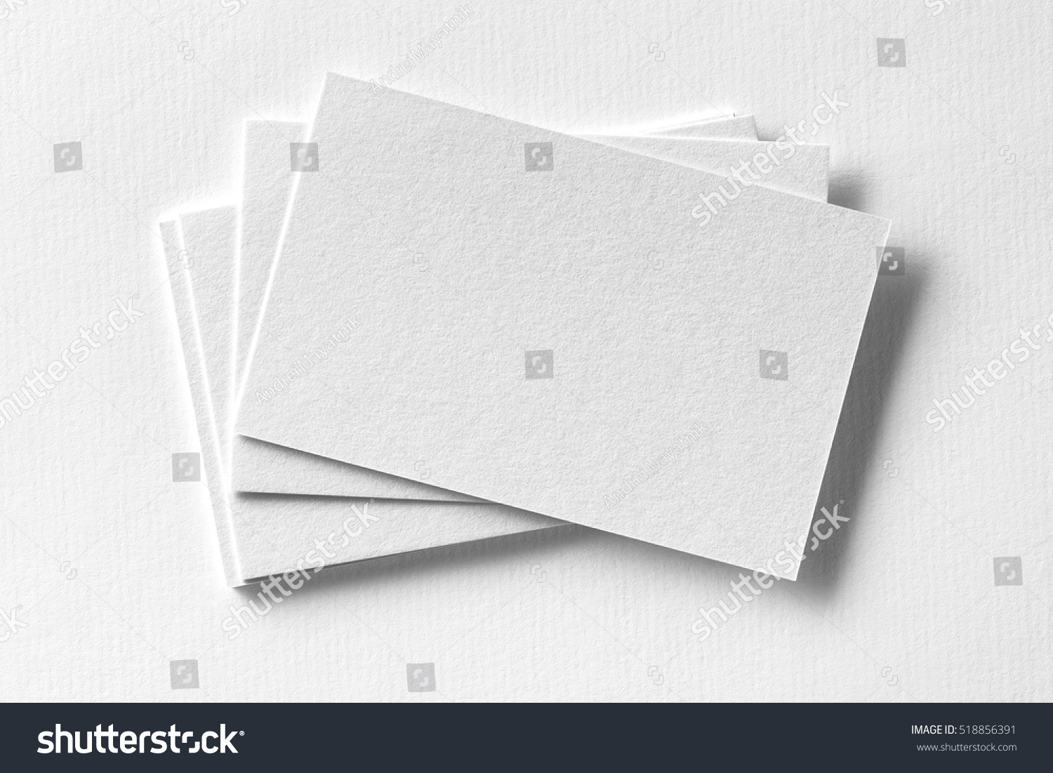 Mockup of business cards fan stack at white textured paper background. #518856391