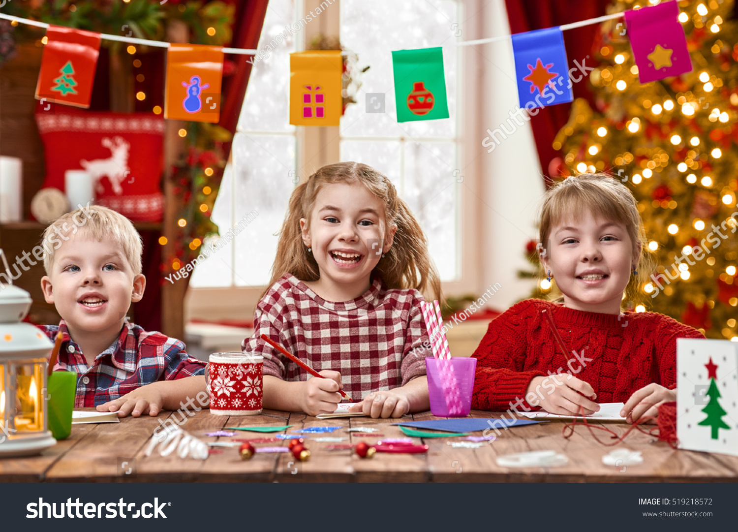 Merry Christmas and Happy Holidays. Adorable little children make cards, gifts and decorations for the holiday. Cute kids are engaged in creativity. #519218572