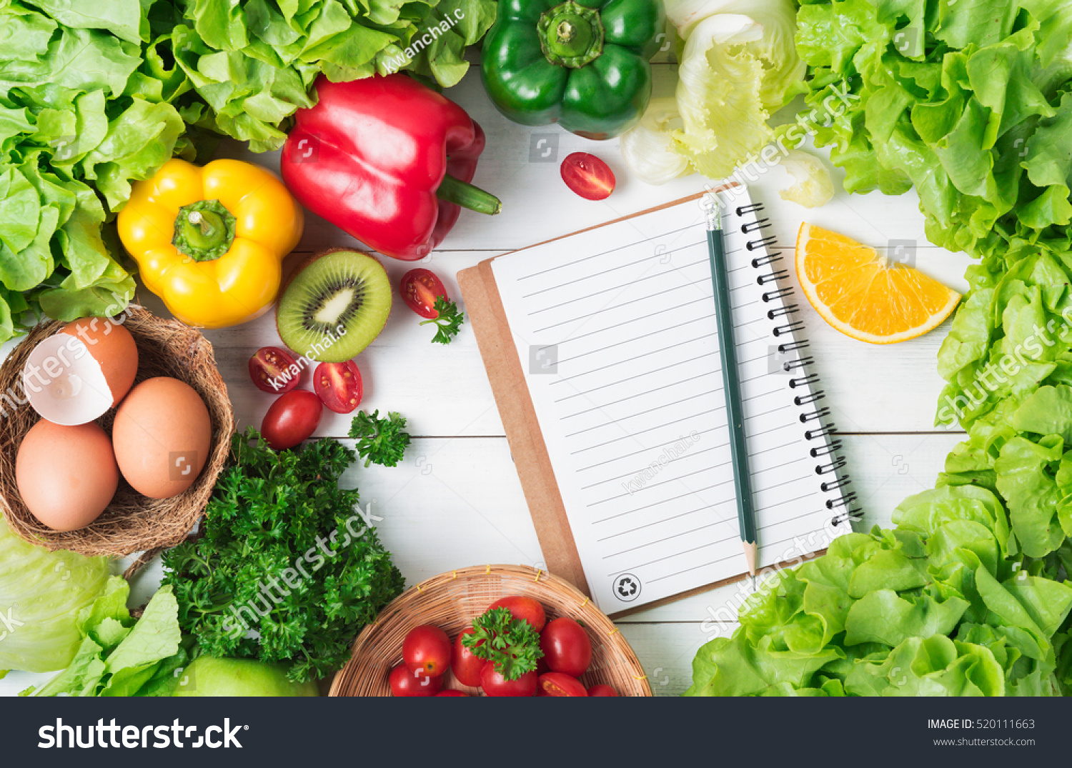 salad vegetables and fruit, tomato, bell pepper, parsley, orange, egg and kiwi fruit with notebook and pencil on wood background and copy space, concept diet and healthy food. #520111663