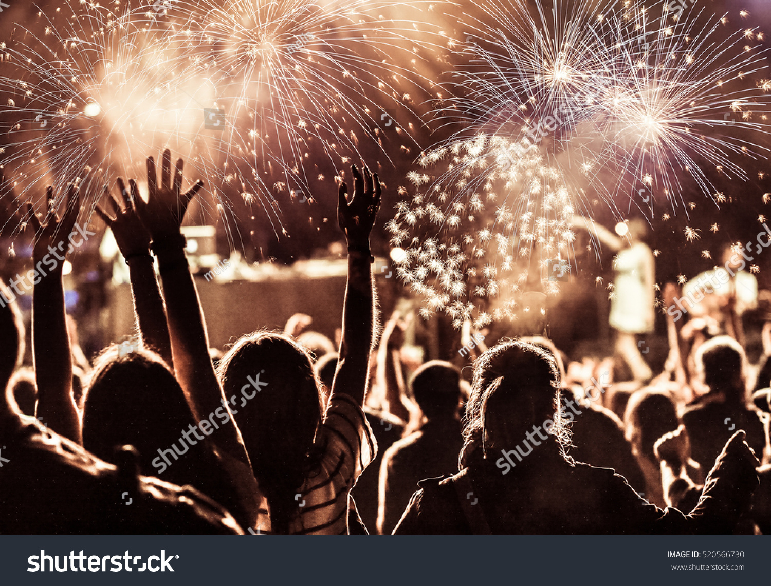 cheering crowd watching fireworks at New Year - holiday celebration background #520566730