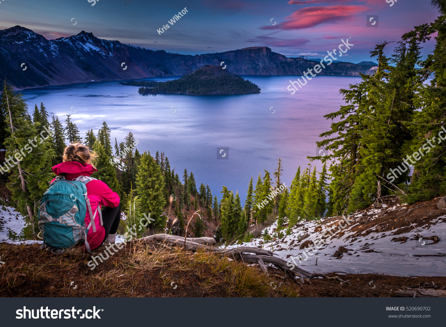 Backpacker Girl Looking at Crater Lake at Sunset Wizar Island and Watchman Peak in the Background #520690702