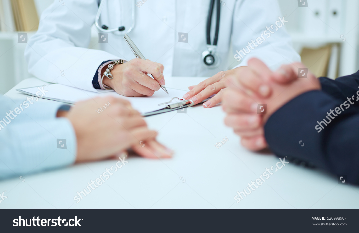 Female medicine doctor hand holding silver pen writing something on clipboard closeup. Ward round, patient visit check, medical calculation and statistics concept. Physician ready to examine patient #520998907