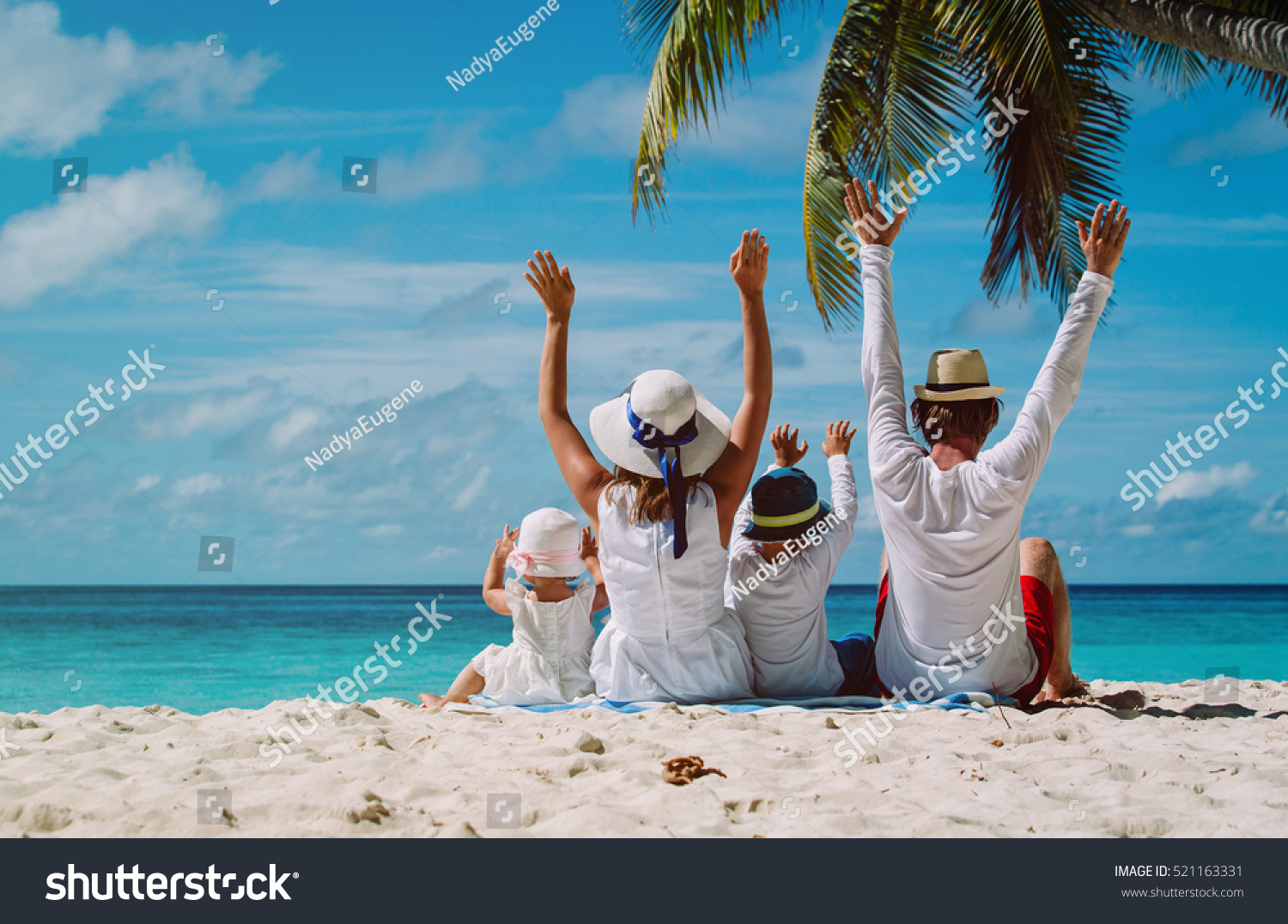 happy family with two kids hands up on the beach #521163331
