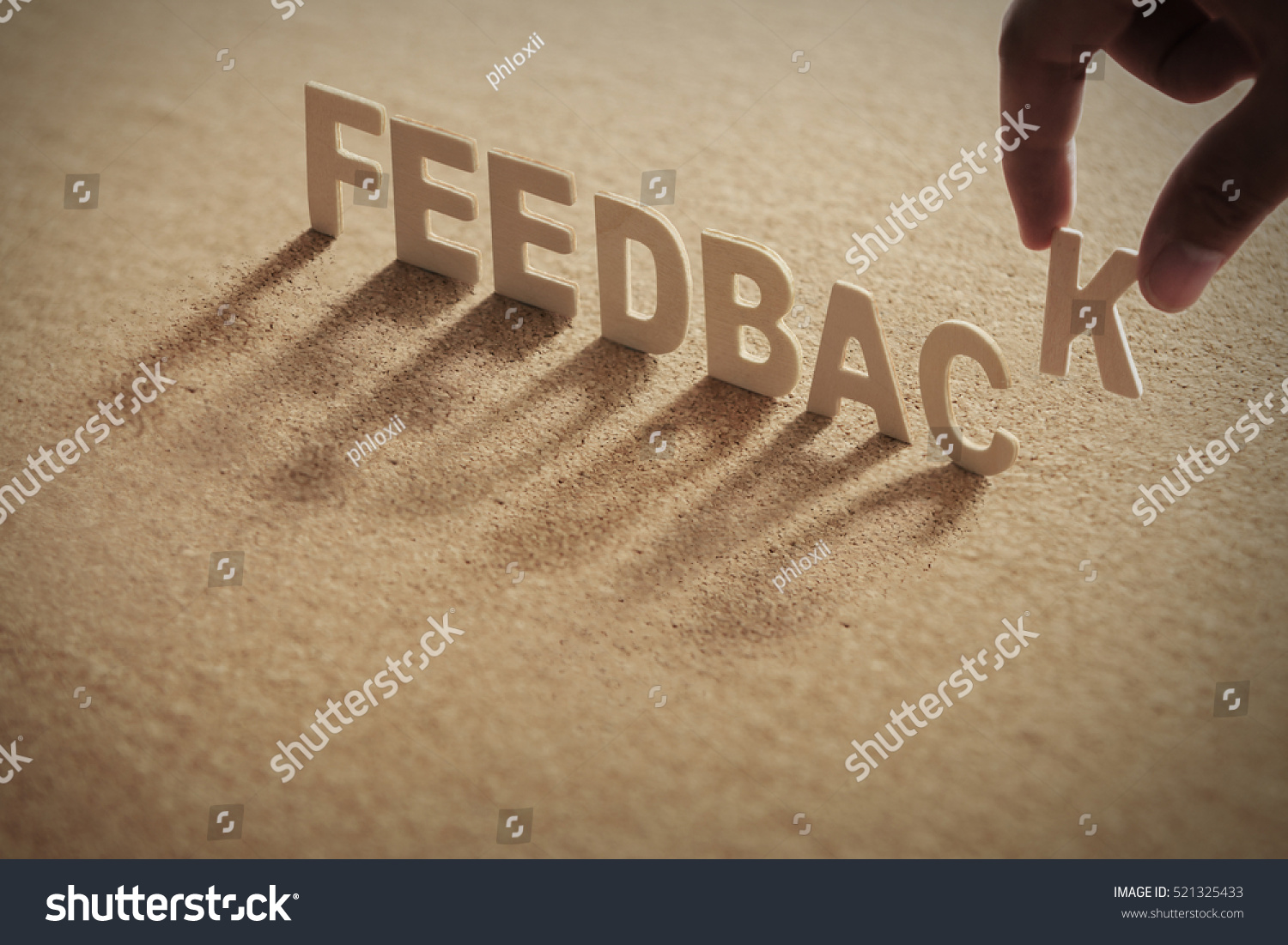 FEEDBACK wood word on compressed board,cork board with human's finger at K letter #521325433