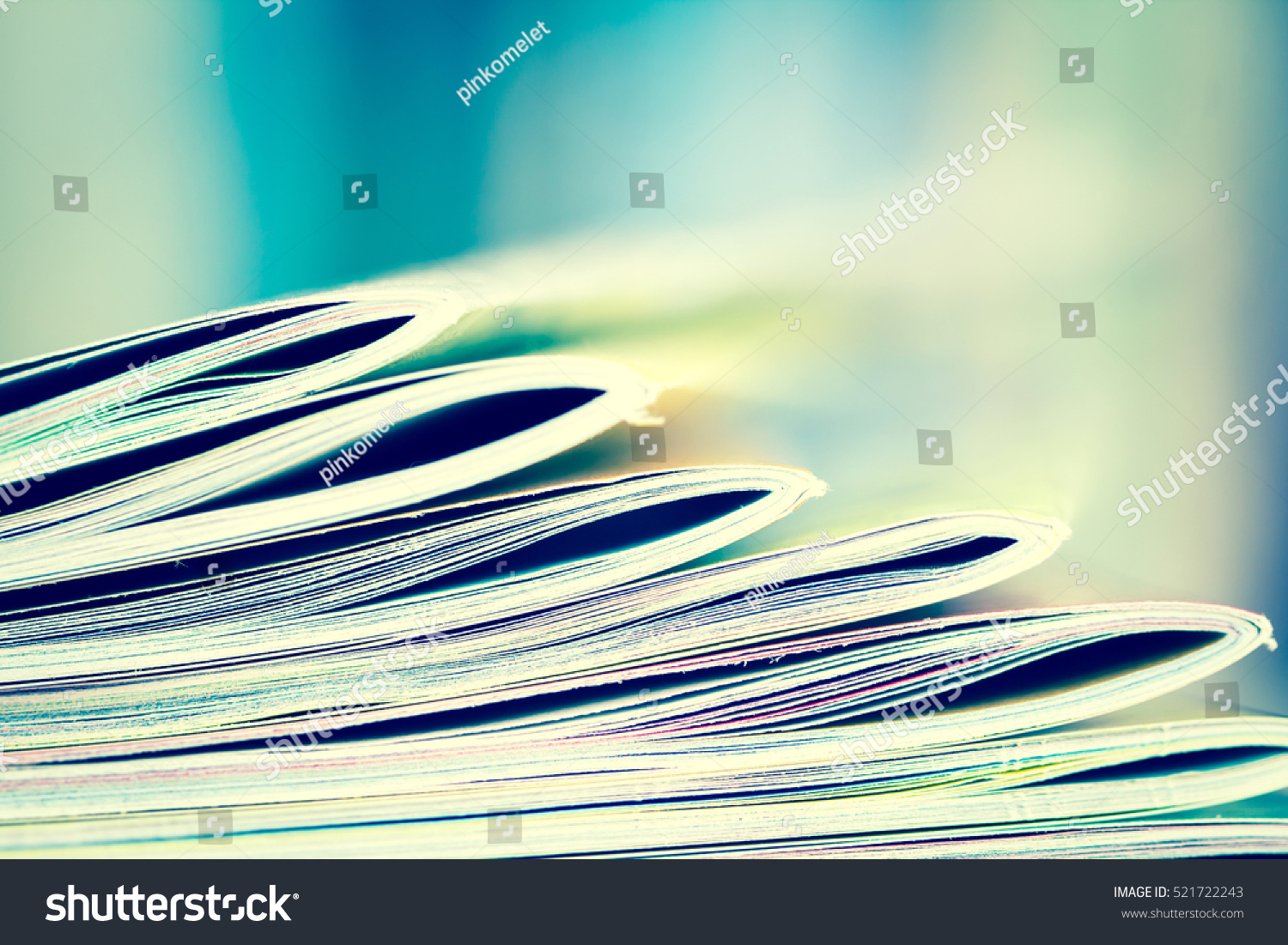 Close up edge of colorful magazine stacking with  blurry bookshelf background for publication and publishing concept , extremely shallow DOF with vintage retro color tone #521722243