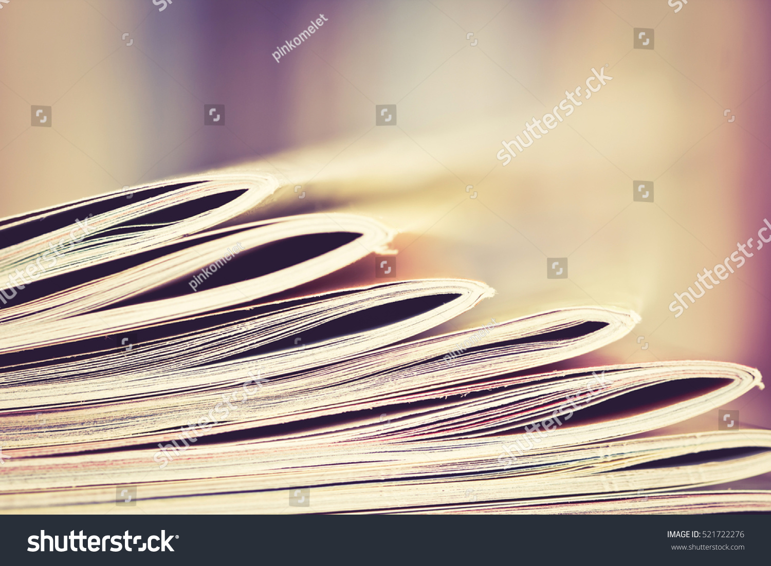 Close up edge of colorful magazine stacking with  blurry bookshelf background for publication and publishing concept , extremely shallow DOF  with vintage retro color tone #521722276