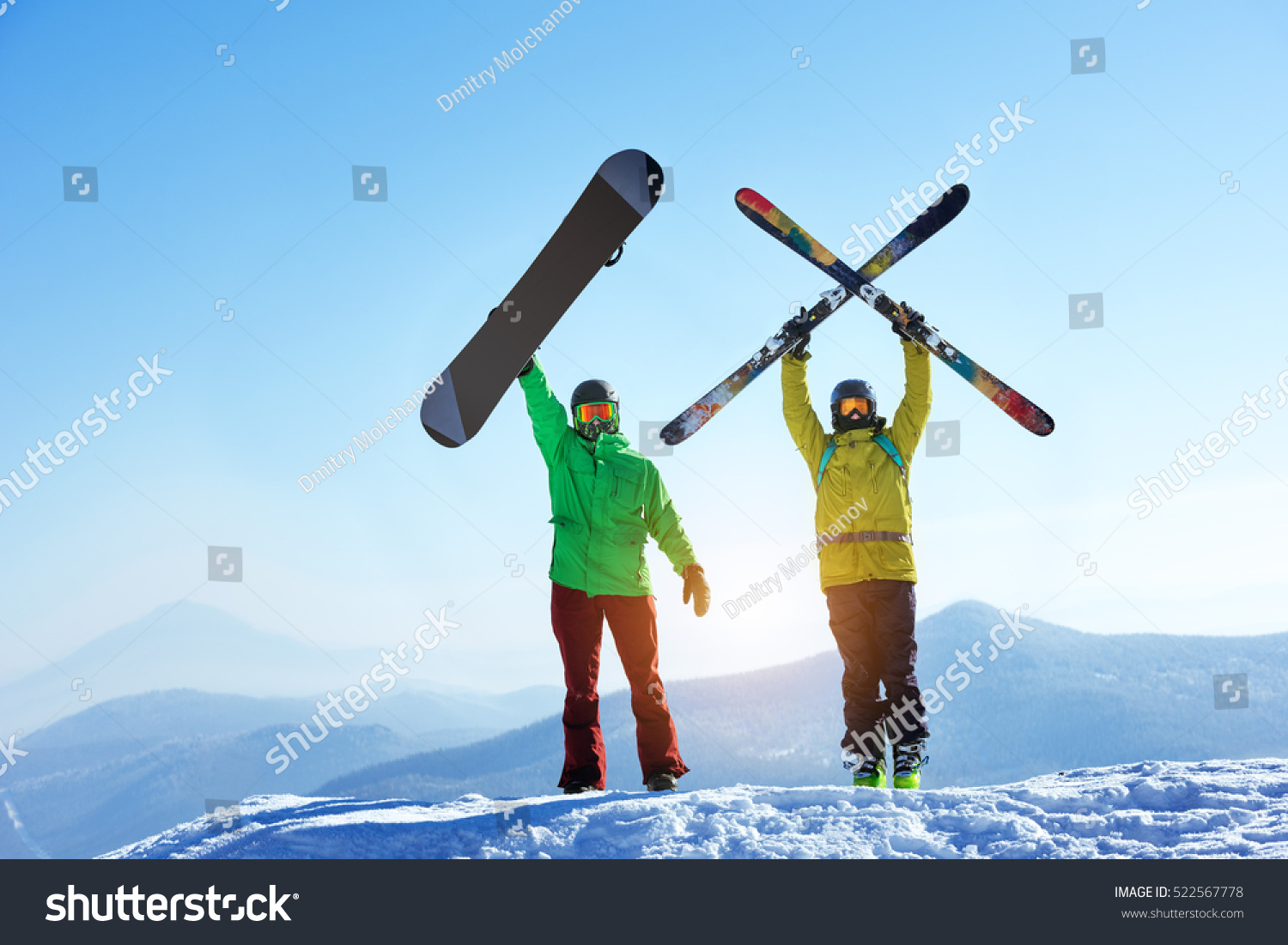Skier and snowboarder stands mountain top with ski and snowboard in hands. Skiing and snowboarding concept. Sheregesh ski resort #522567778