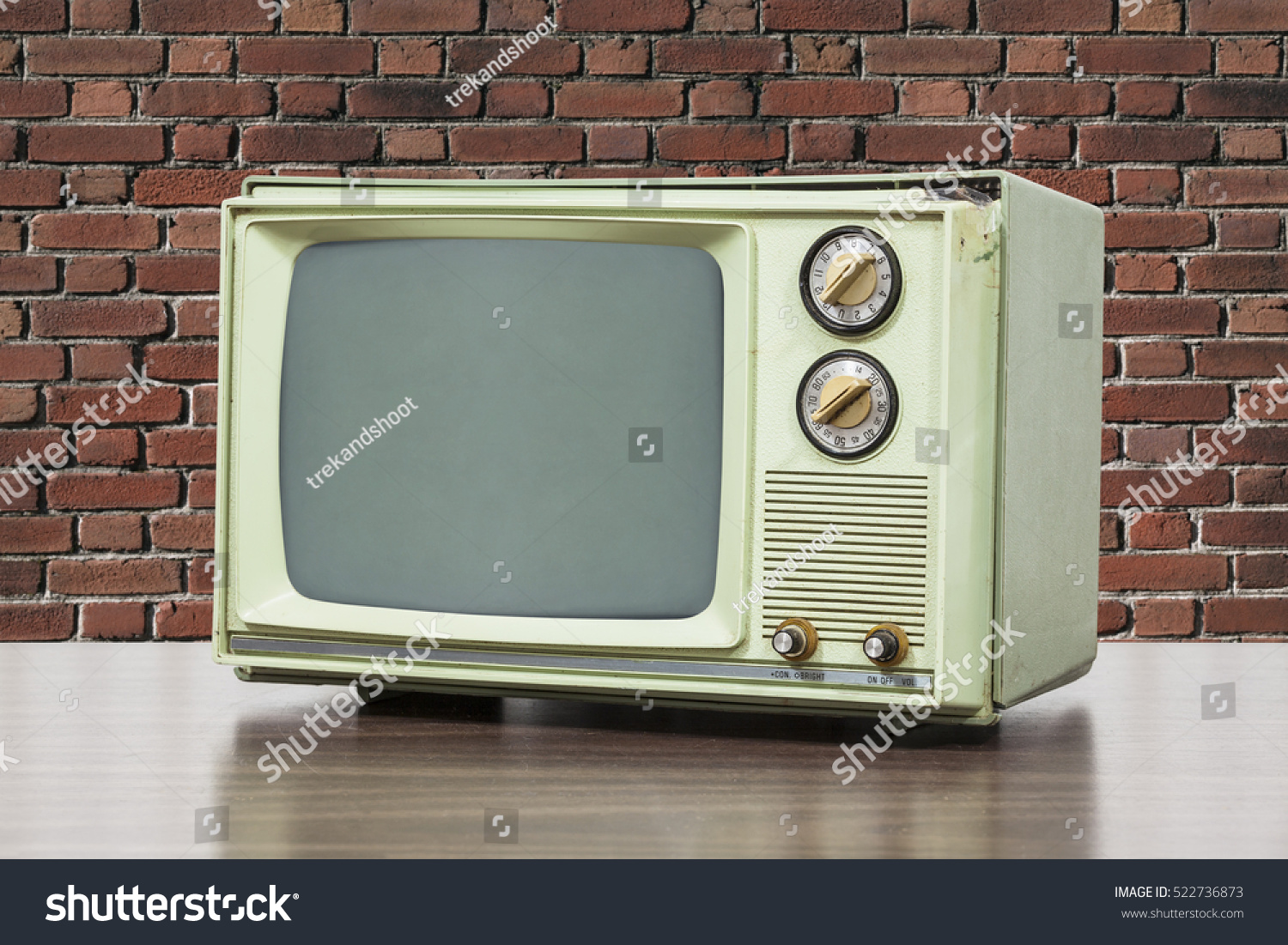 Green vintage television with brick wall. #522736873