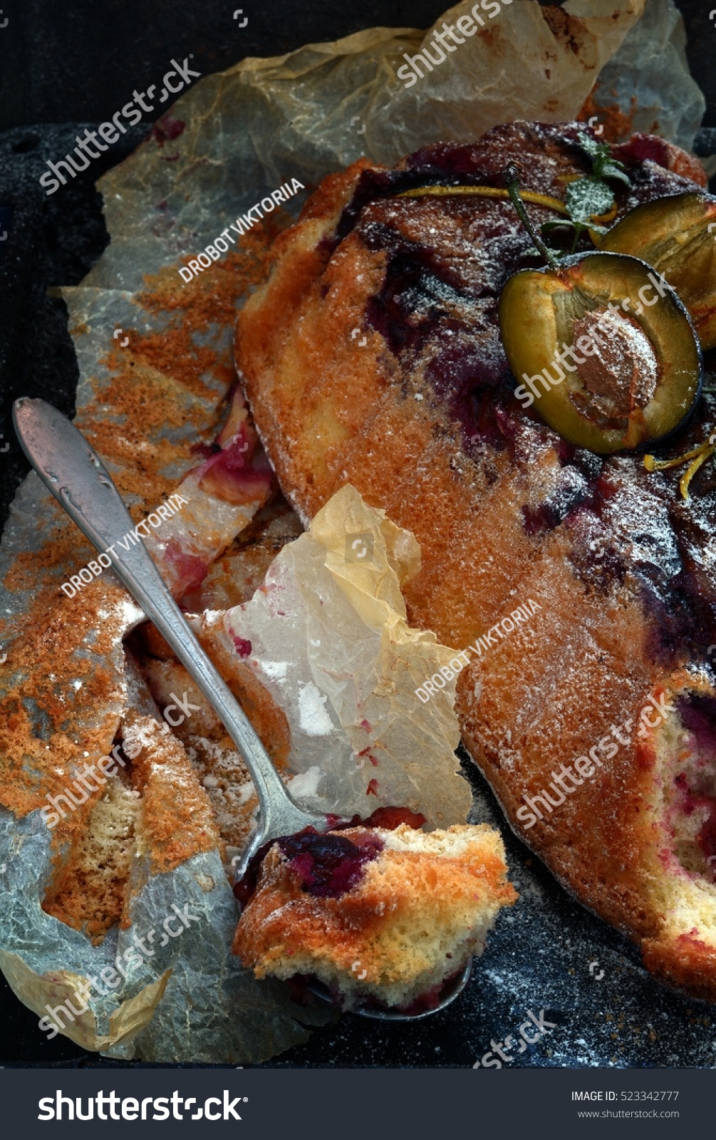 air sponge cake with plums and icing sugar on a dark background #523342777