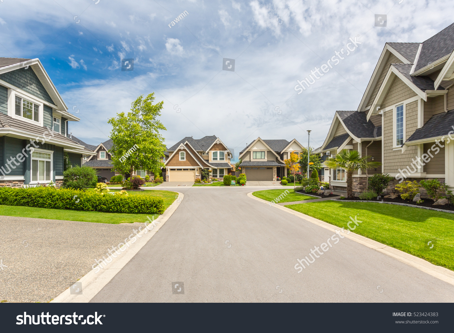 Nicely trimmed and manicured garden in front of a luxury house on a sunny summer day. Street of houses in the suburbs of Canada. #523424383