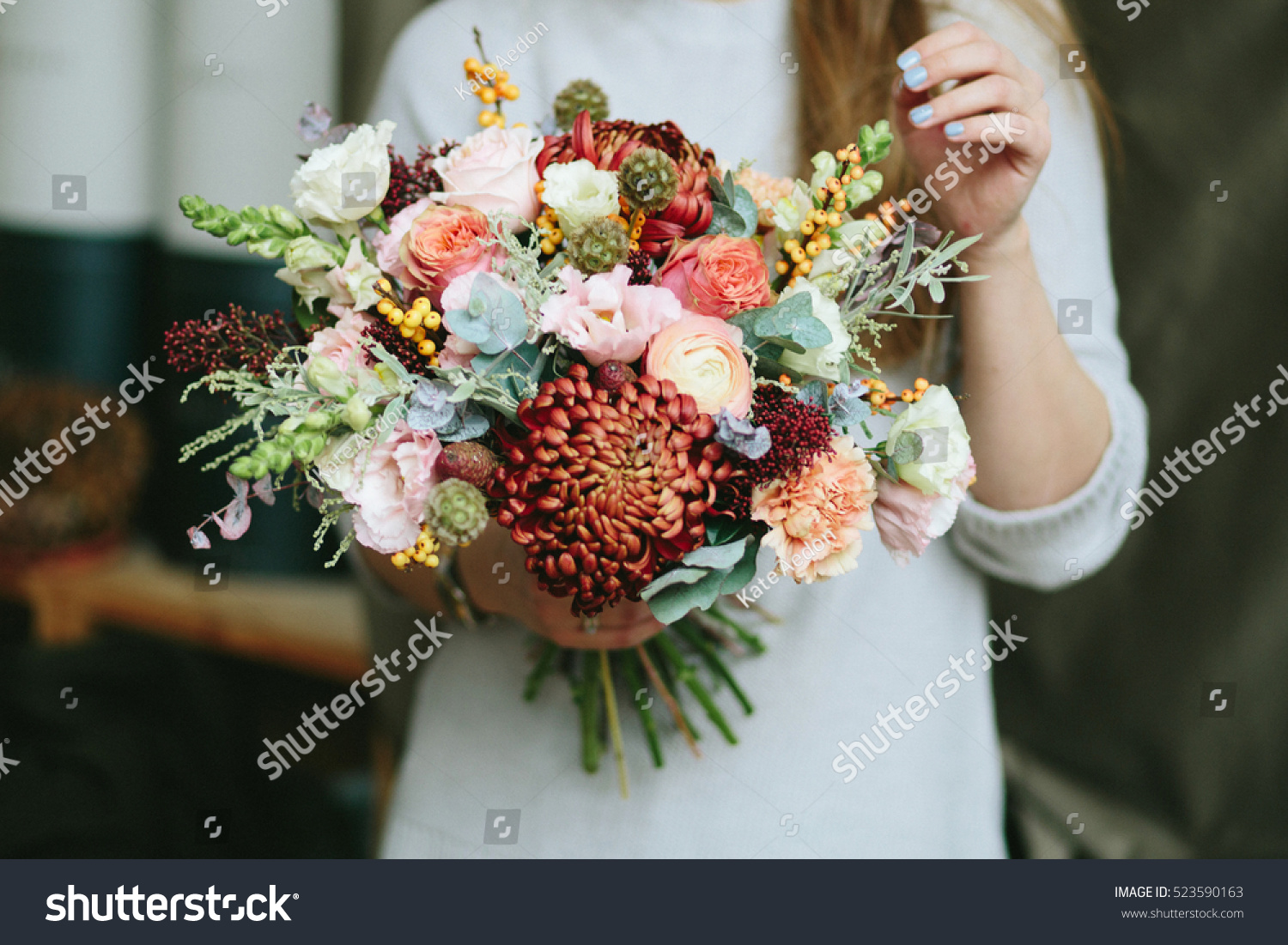 Florist shop in daylight. Woman holding beautiful bouquet of flowers. Florist with her work. Stylized tender photo with hipster filter.  #523590163
