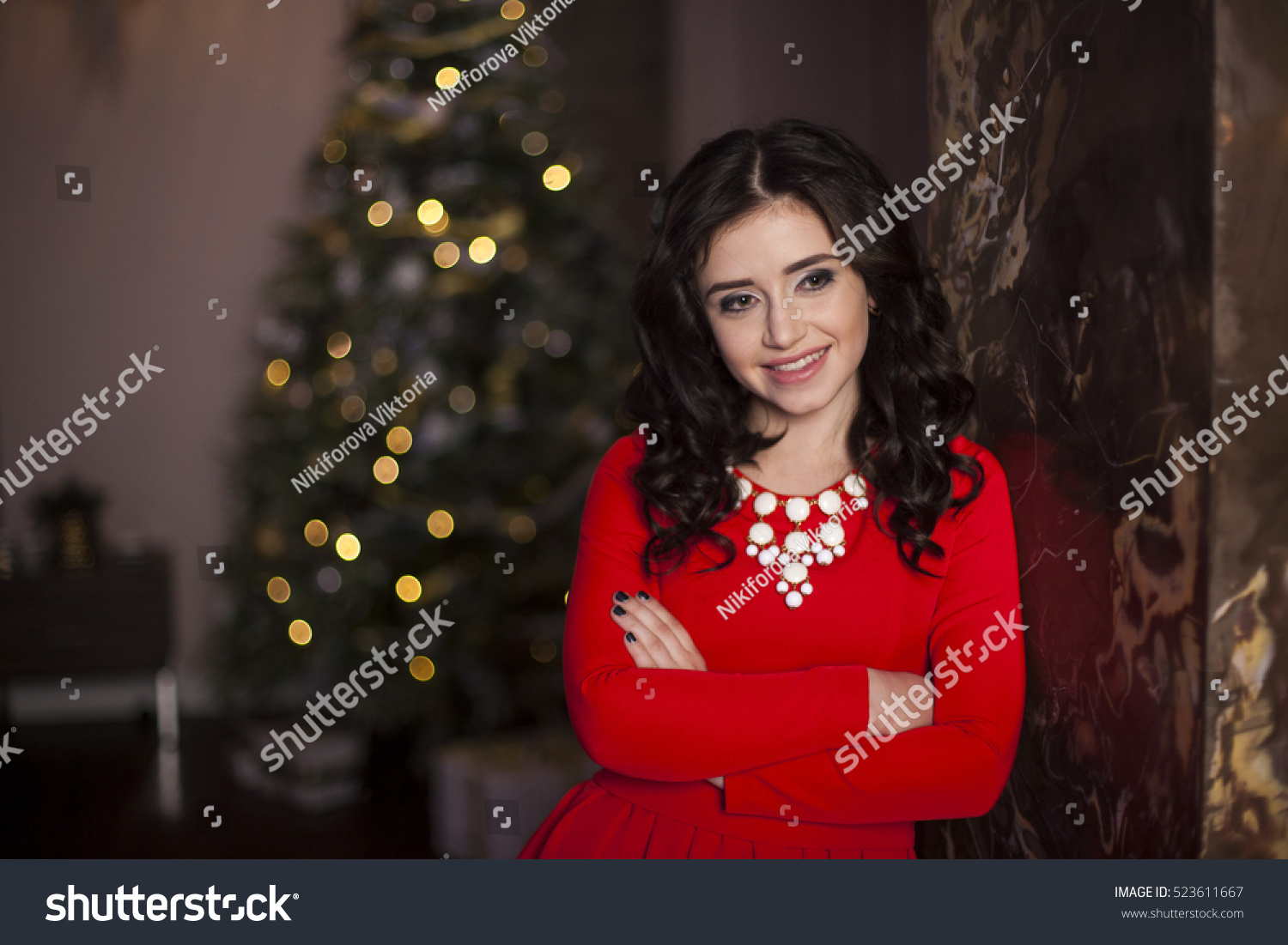 Cute girl in red dress with Christmas tree #523611667