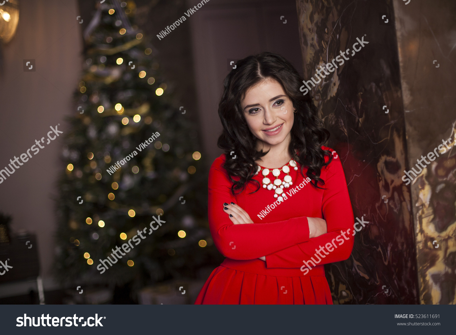 Cute girl in red dress with Christmas tree #523611691