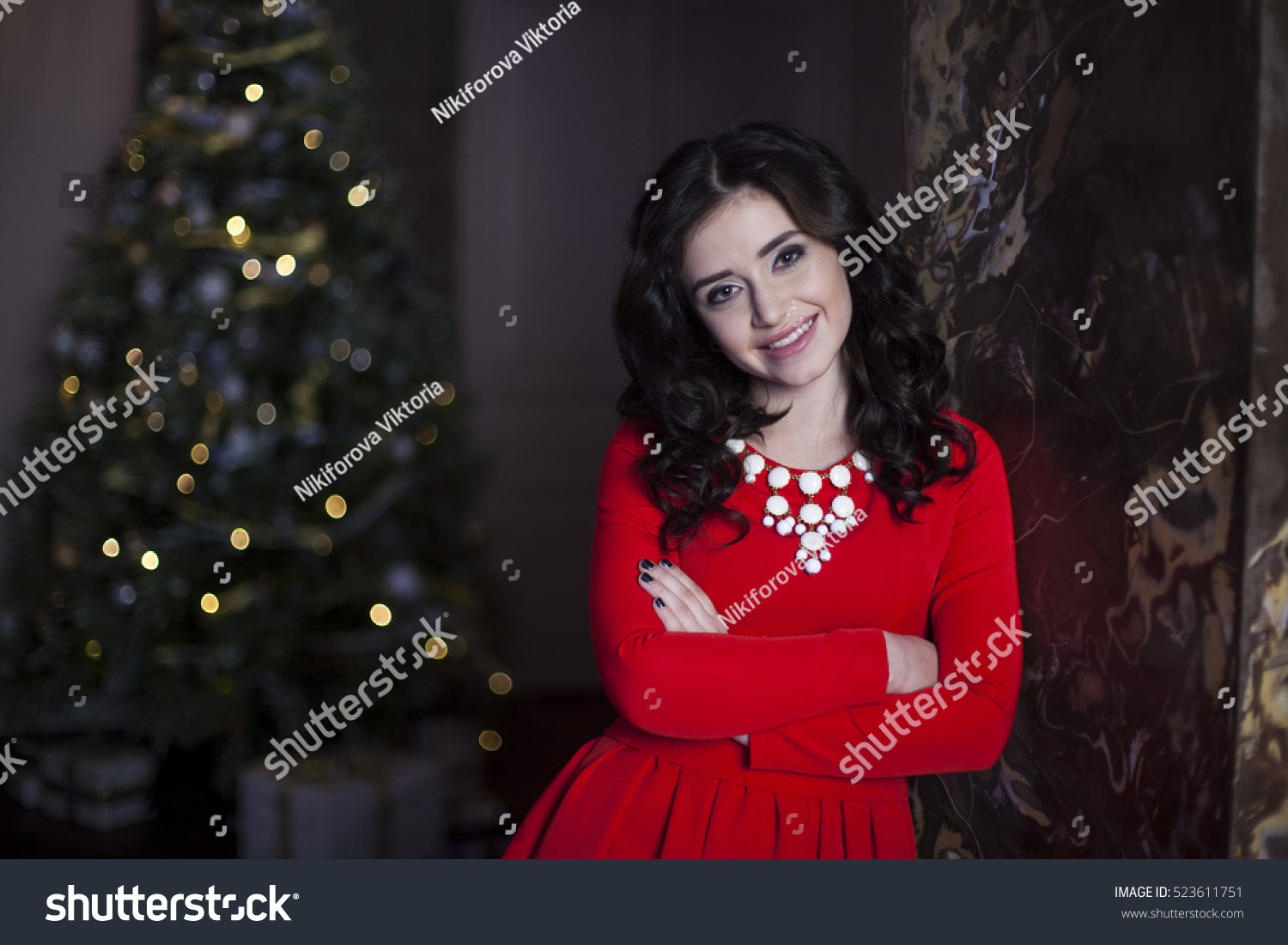 Cute girl in red dress with Christmas tree #523611751