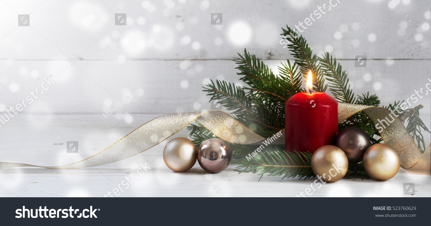 Red burning candle with christmas decoration, fir tree, baubles and ribbon, in front of a white  wooden wall with bokeh lights and generous copy space, panorama, selective focus, narrow depth of field #523760629