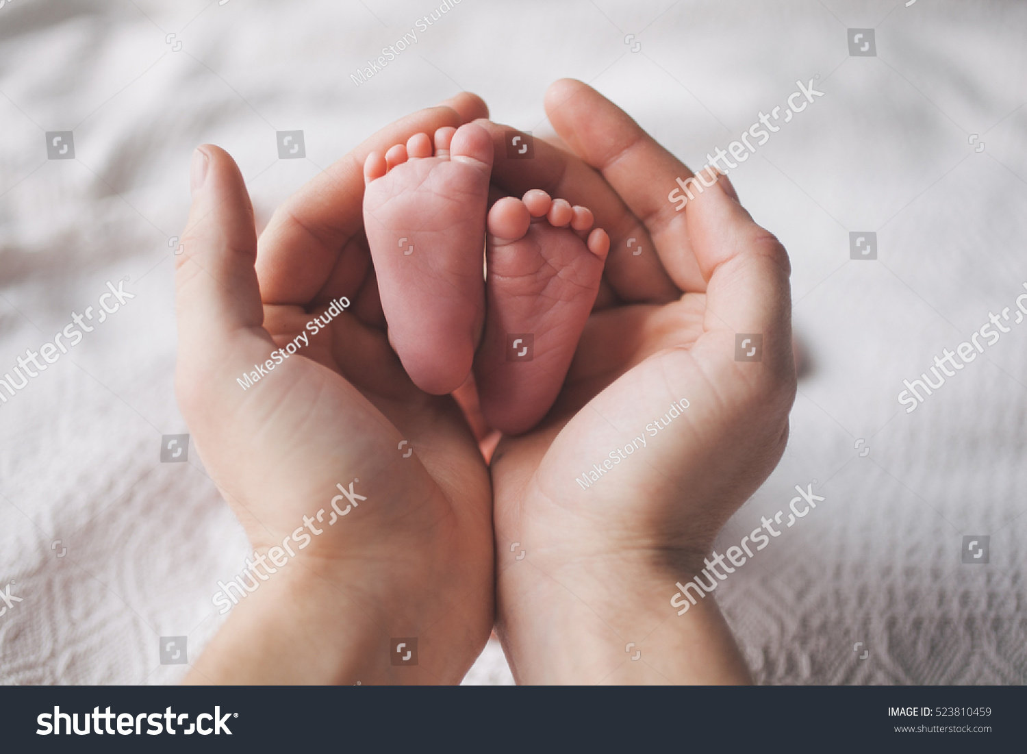 Parent holding in the hands feet of newborn baby. #523810459