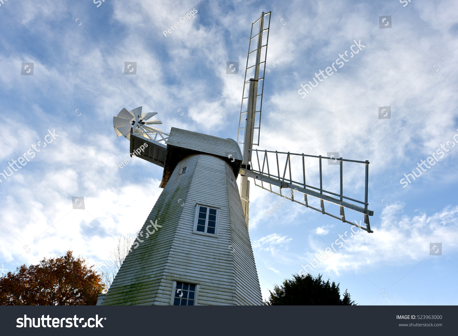 White wooden windmill in front of blue sky #523963000