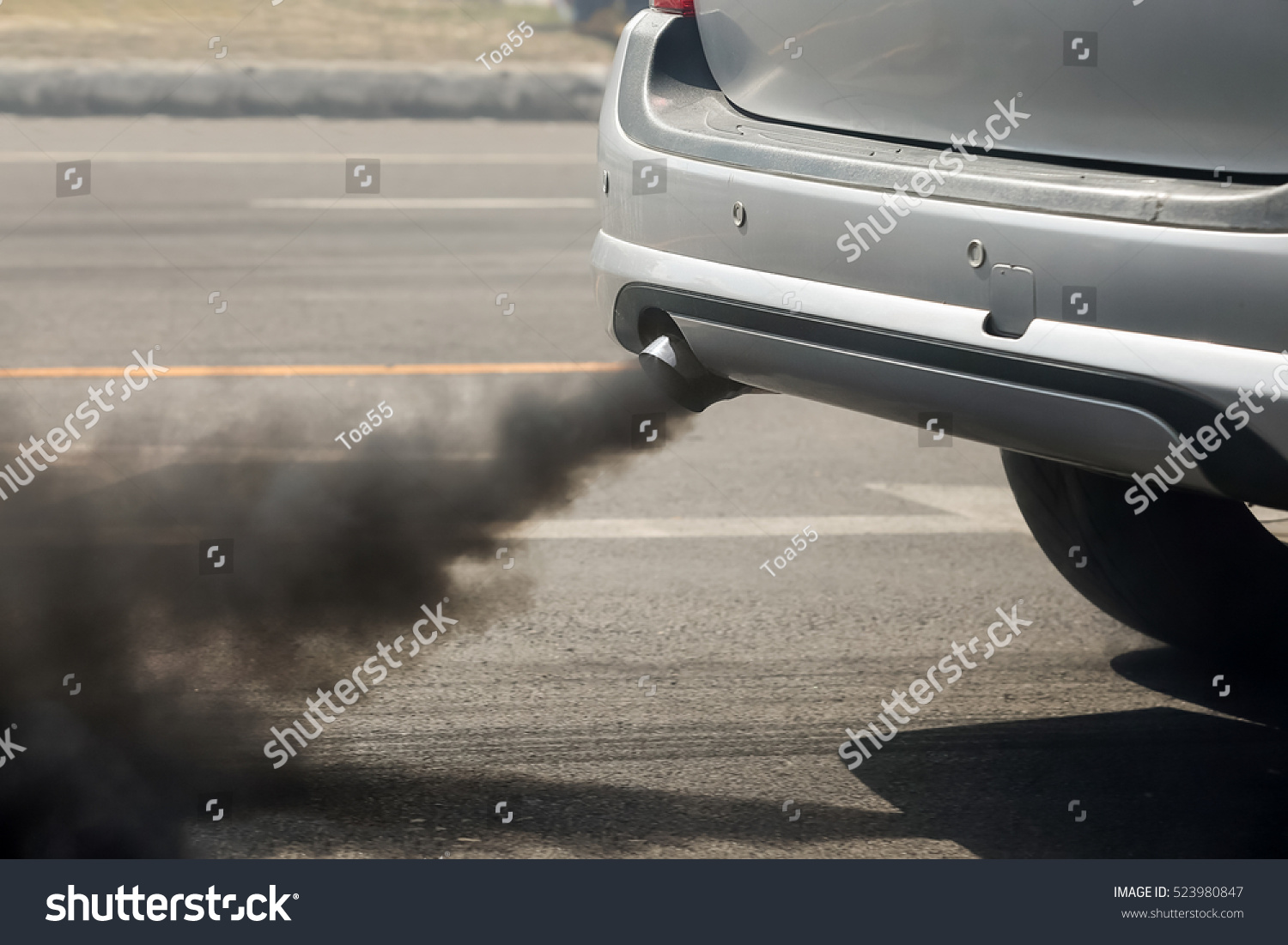 Air pollution from vehicle exhaust pipe on road #523980847