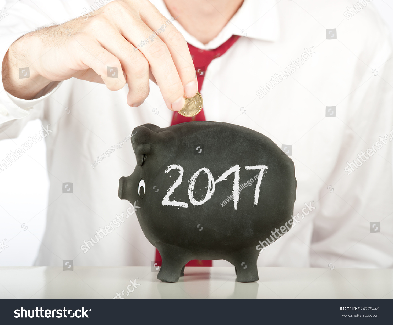 businessman putting money on a piggy bank with a year 2017 drawing #524778445
