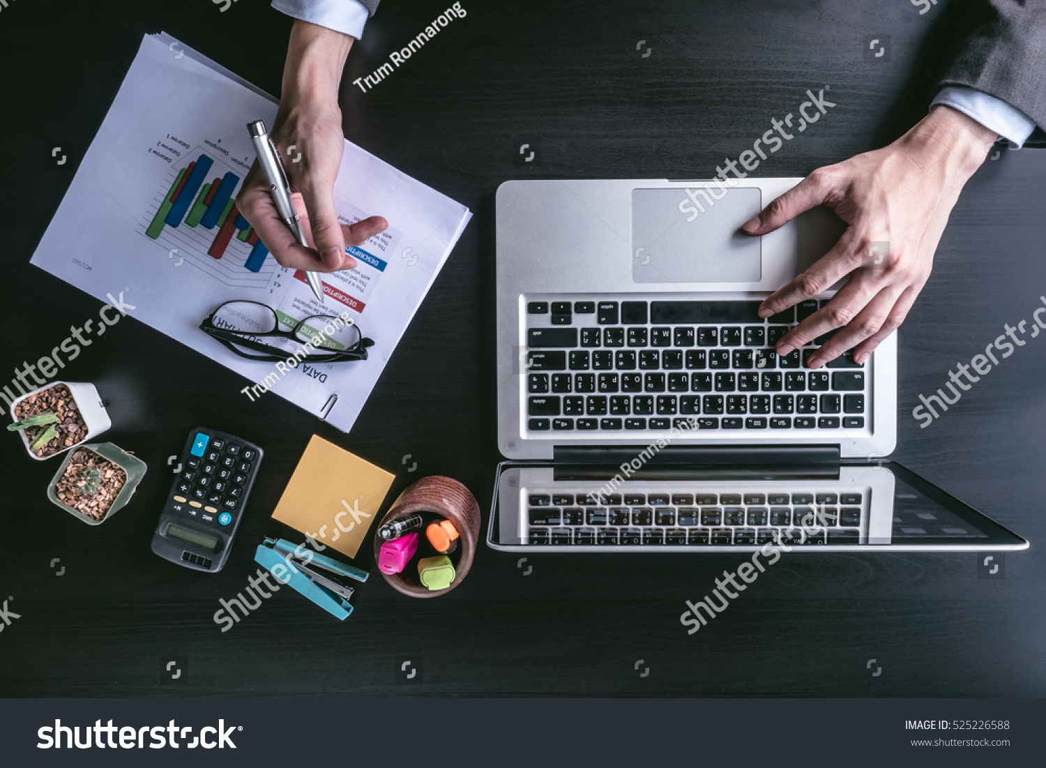 Top view of Businessman using laptop with analyzing investment charts on the office desk. #525226588