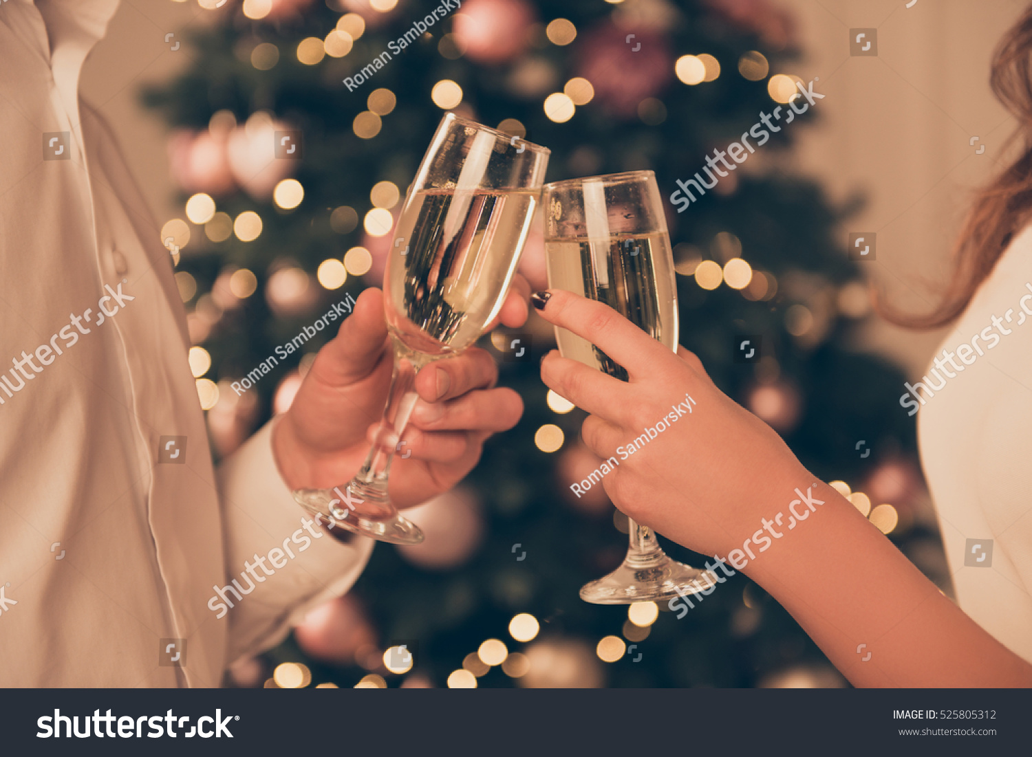 Cheers!Close up photo of two people holding glasses of shampagne on xmas. #525805312