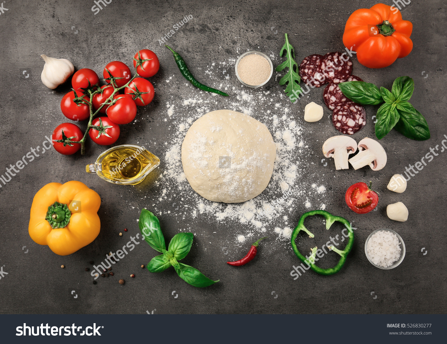 Raw dough for pizza with ingredients and spices on table #526830277