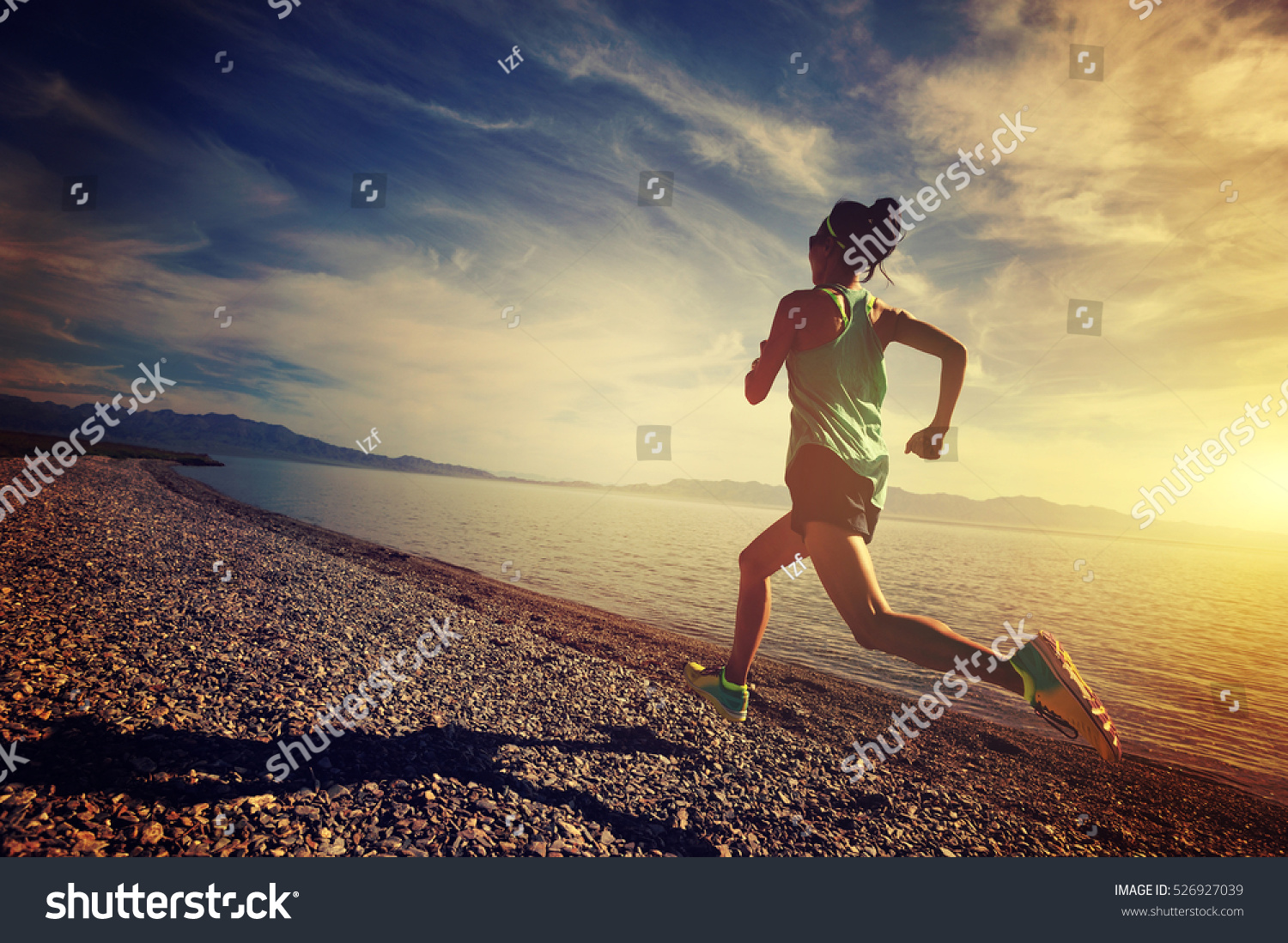healthy lifestyle young woman runner running on sunrise seaside #526927039