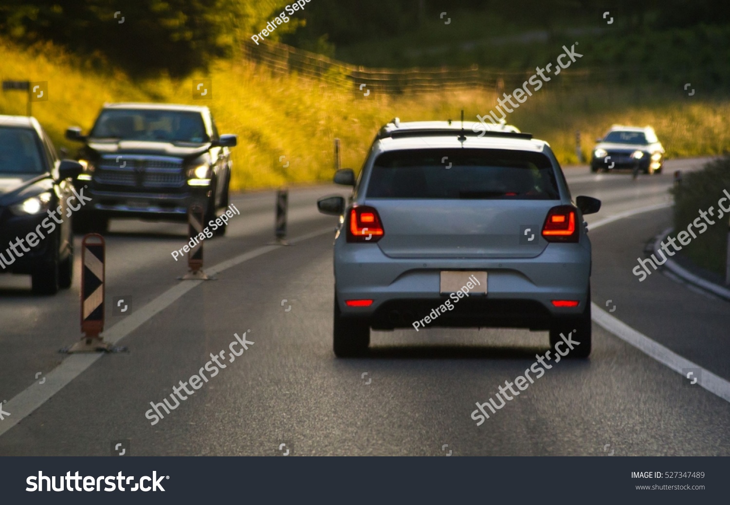 Cars on busy road driving in evening #527347489