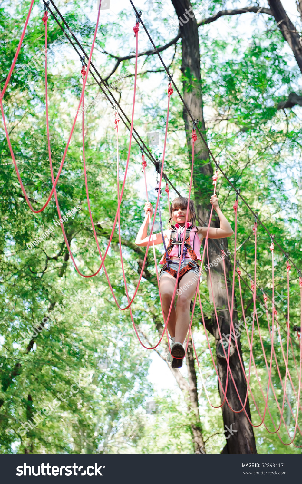 adventure climbing high wire park - hiking in the rope park girl in safety equipment #528934171