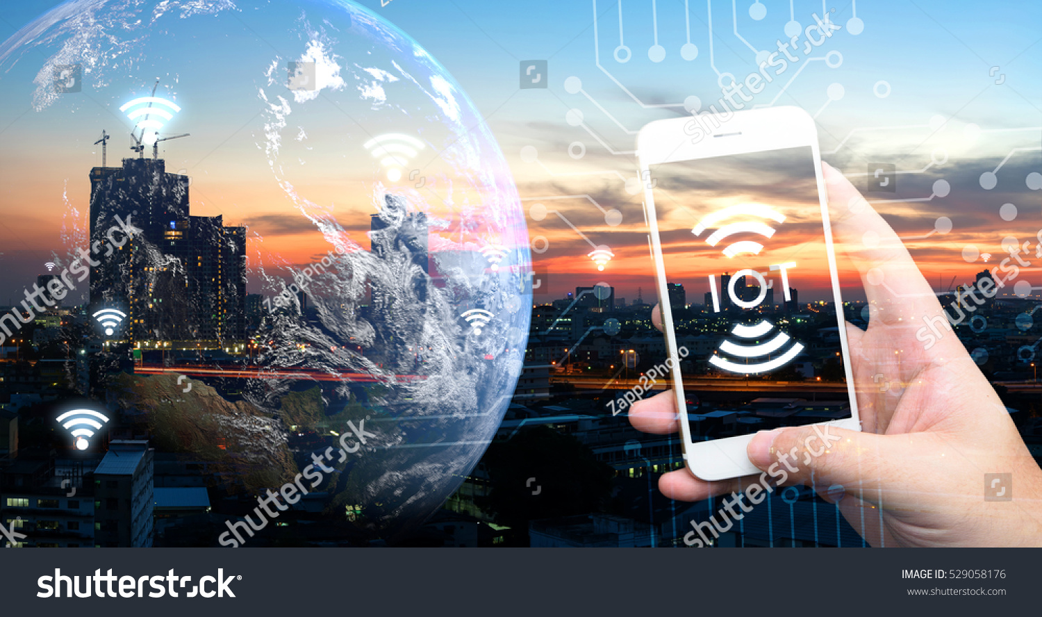 Internet of things , iot , smart home , smart city and network connect concept. Human hand holding white phone and iot icon with city sunset view and earth furnished by NASA. background and wifi icons #529058176