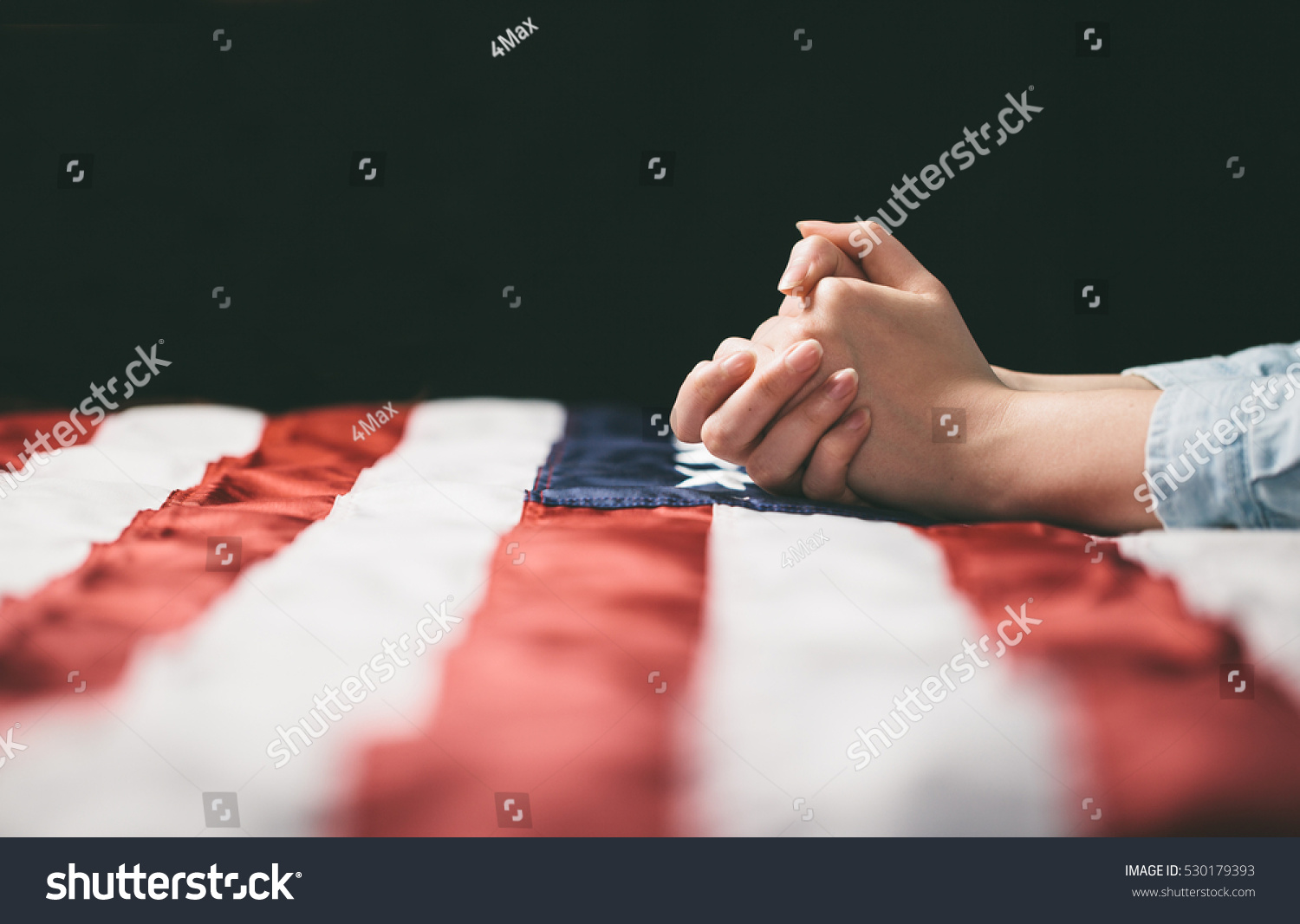 Hands praying over USA flag #530179393