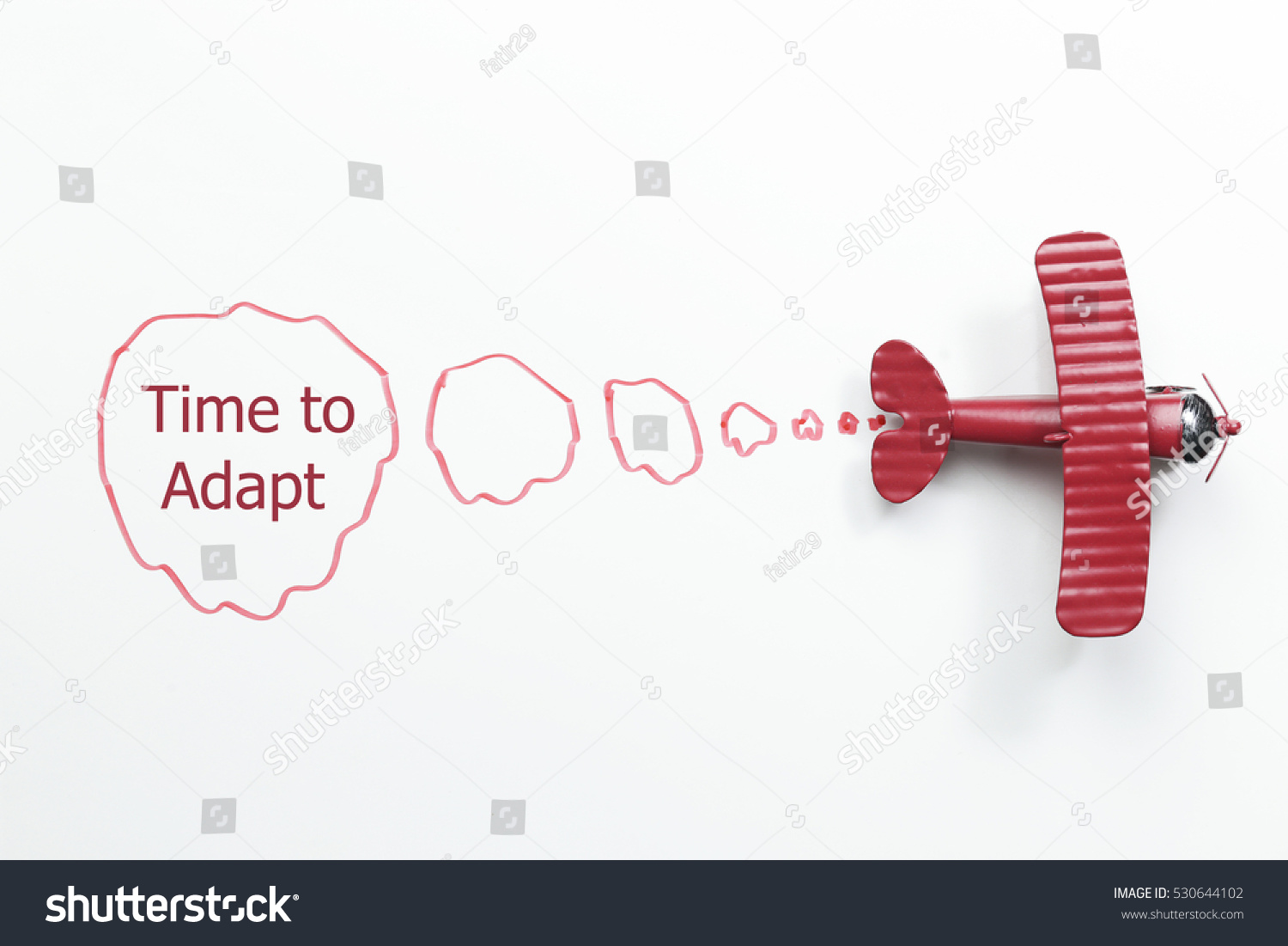 writing time to adapt red toy airplane with talk bubble on white background #530644102