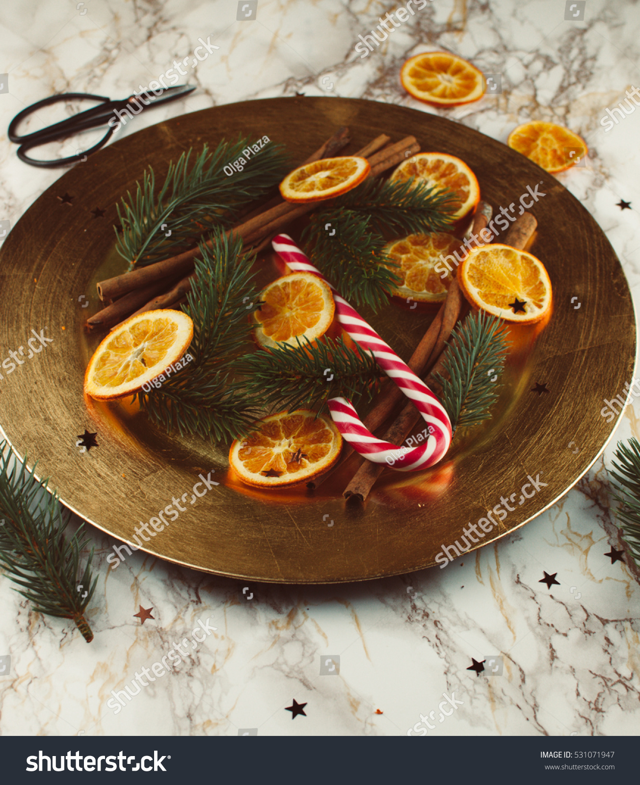 Golden, vintage, christmas decoration on a golden plate with dried oranges and sweets #531071947