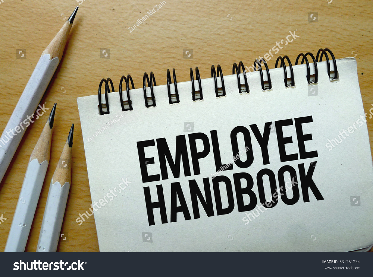 Employee Handbook text written on a notebook with pencils #531751234