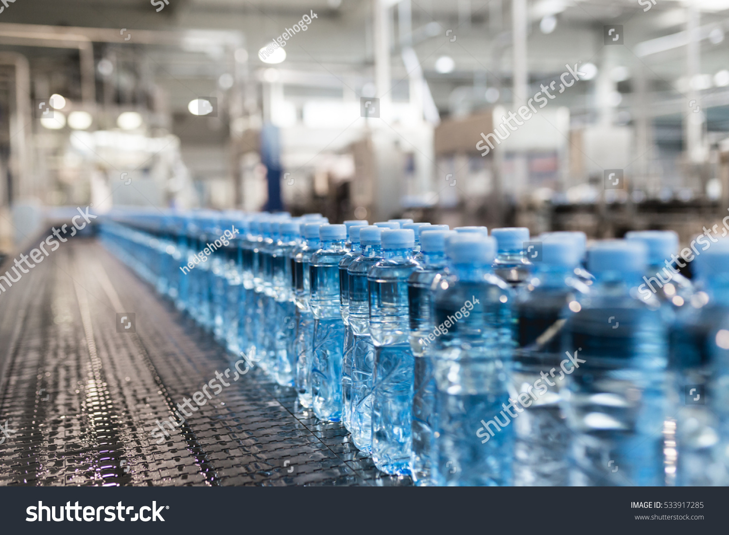 Water factory - Water bottling line for processing and bottling pure spring water into green glass small bottles. Selective focus. #533917285
