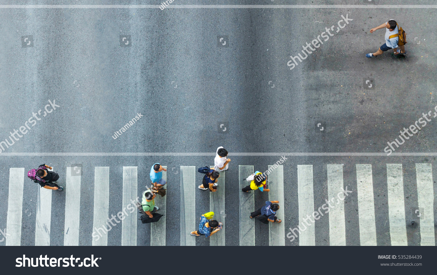 the one man walk converse,  the busy city crowd move to pedestrian crosswalk on businees traffric road (Aerial photo, top view)  #535284439