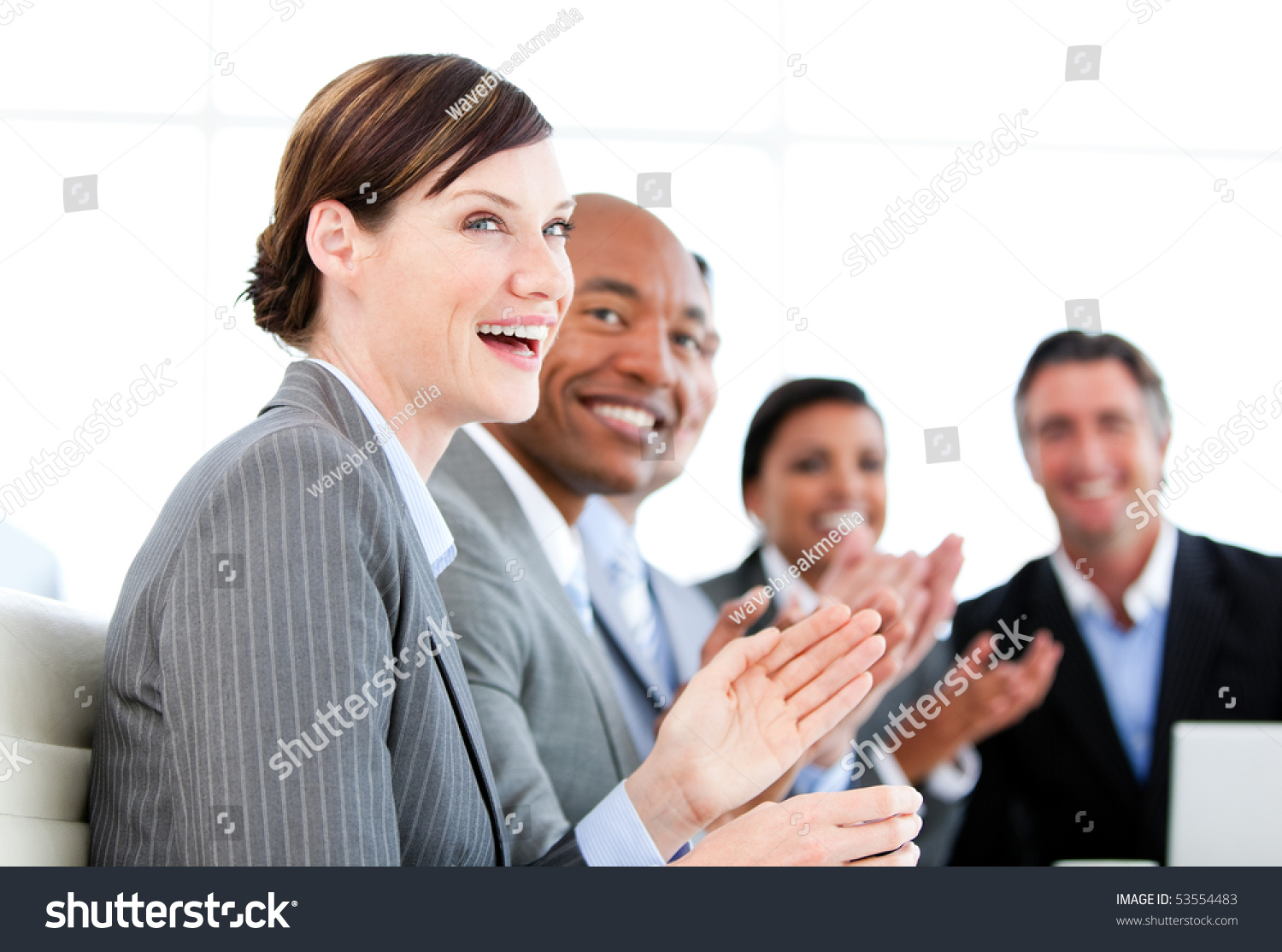 Portrait of smiling businessteam applauding a presentation against a white background #53554483