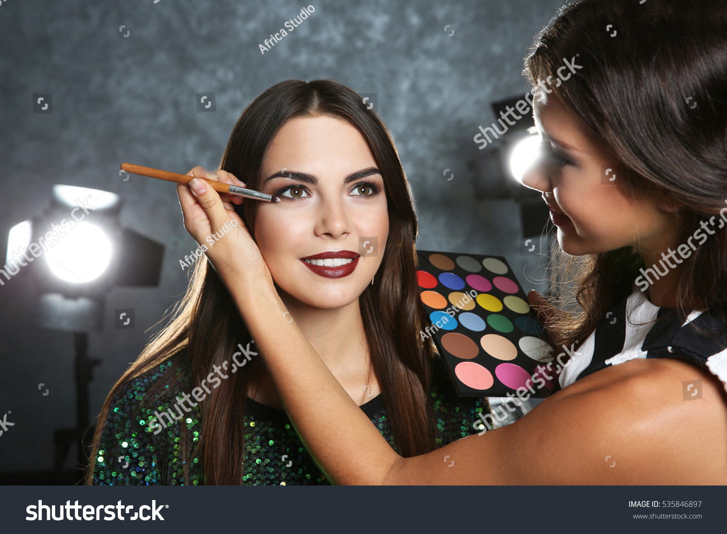 Professional makeup artist working with beautiful young woman #535846897