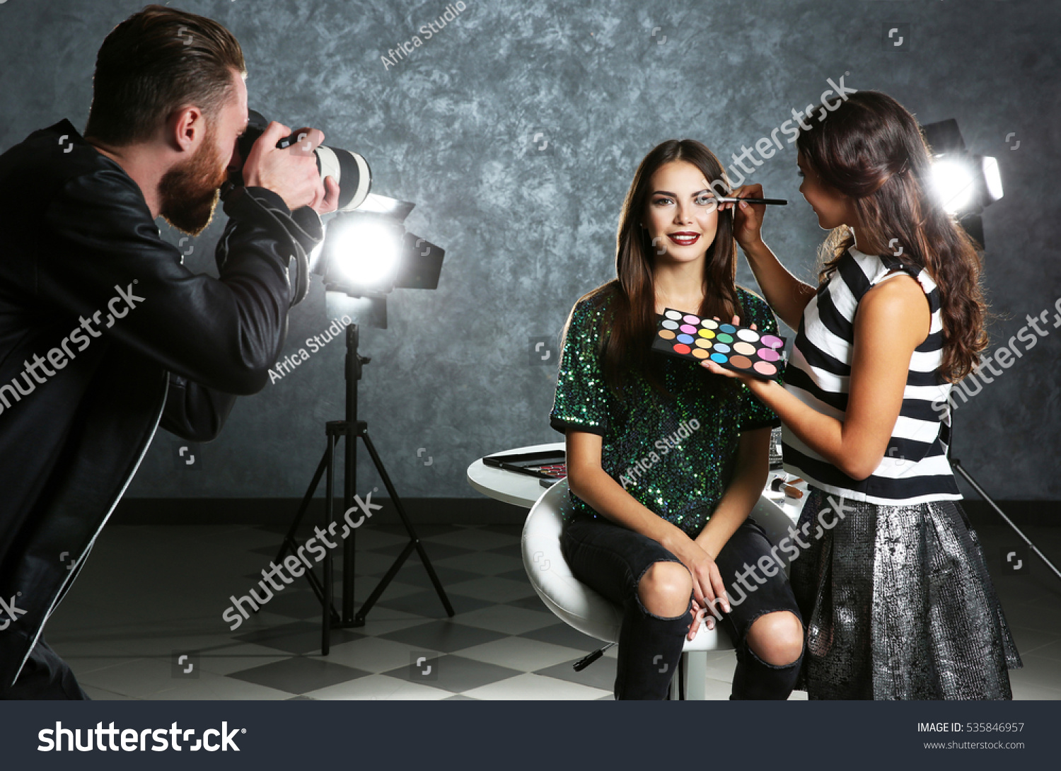 Professional makeup artist working with young beautiful woman at photo shooting #535846957
