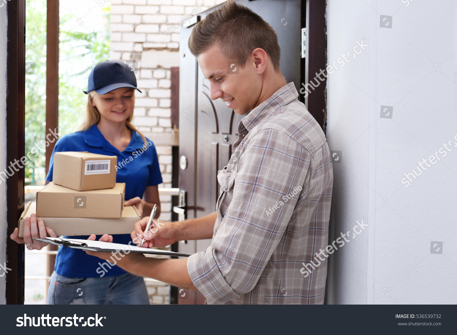 Young man receiving package from courier #536539732
