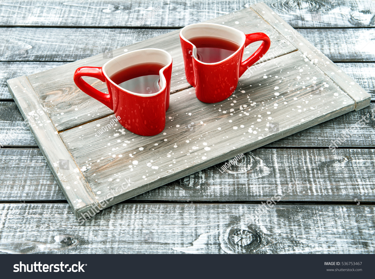 Heart shaped cups with red drink on rustic wooden background. Valentines day #536753467