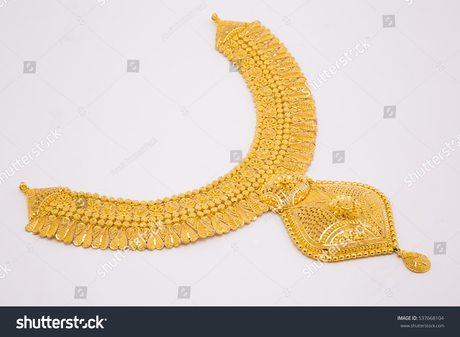Beautiful gold neckless isolated on black background. Gold jewellery stock photo. #537668104
