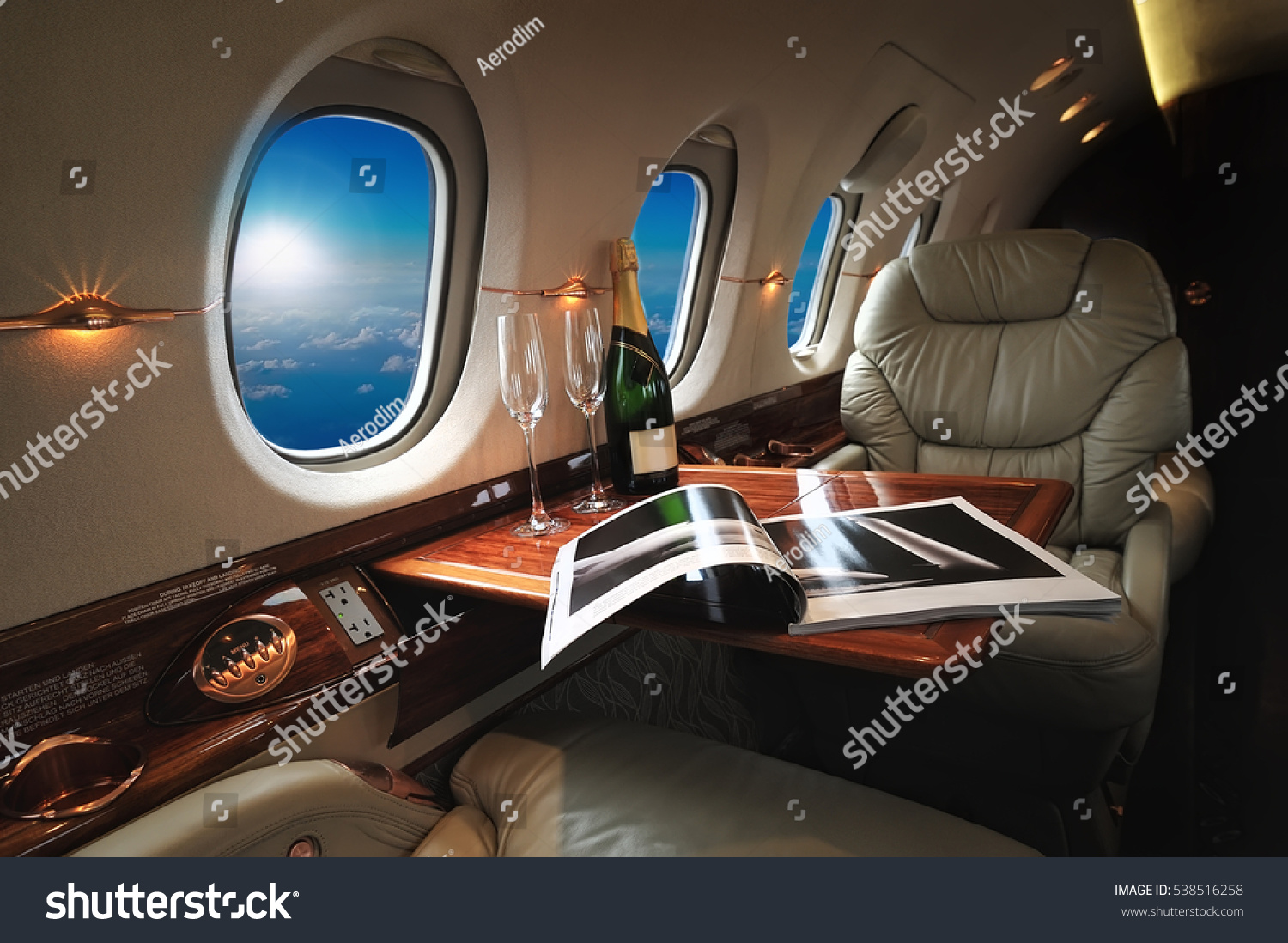 luxury interior in the modern  business jet and sunlight at the window/sky and clouds through the porthole #538516258
