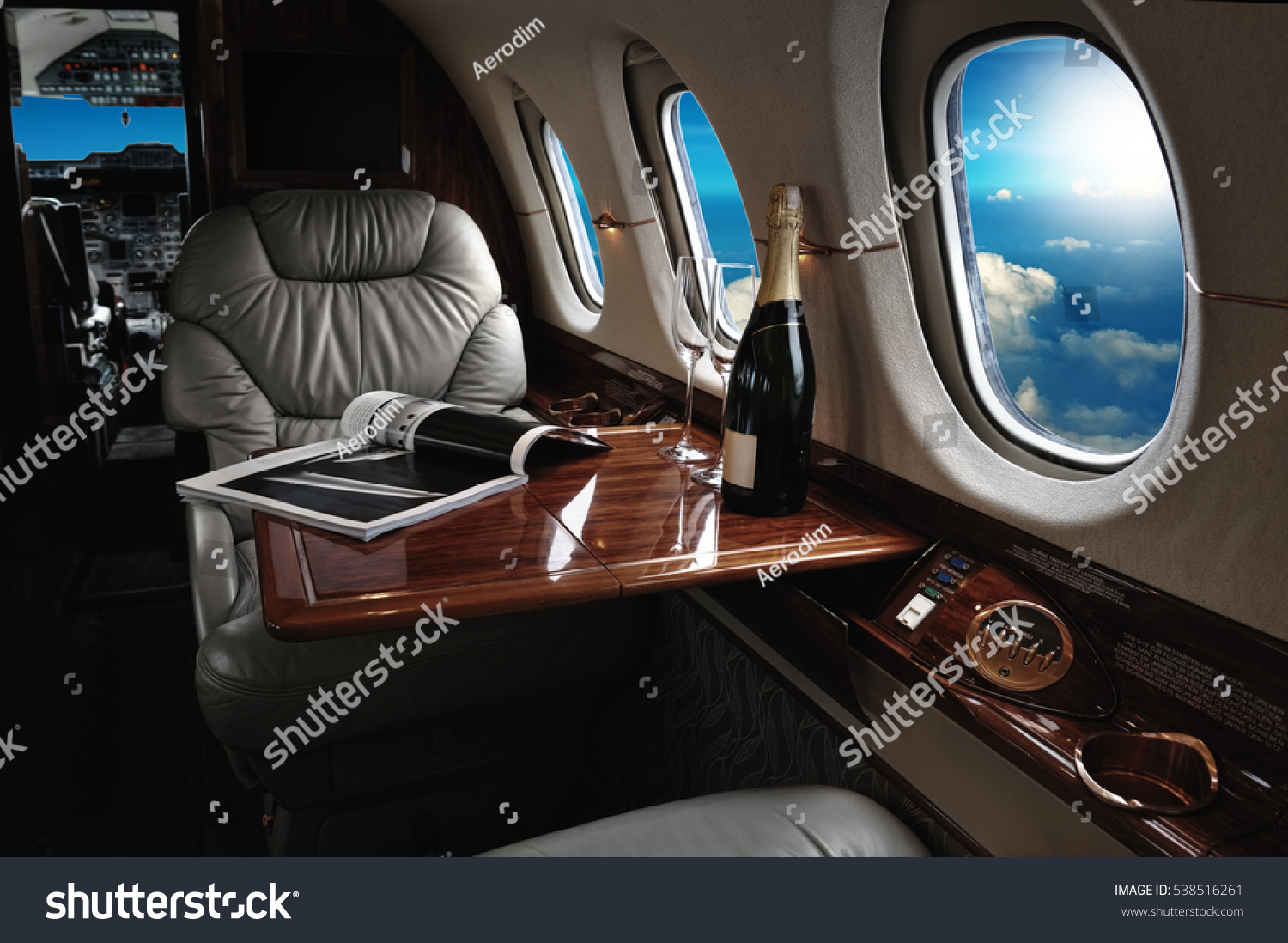 luxury interior in the modern  business jet and sunlight at the window/sky and clouds through the porthole #538516261