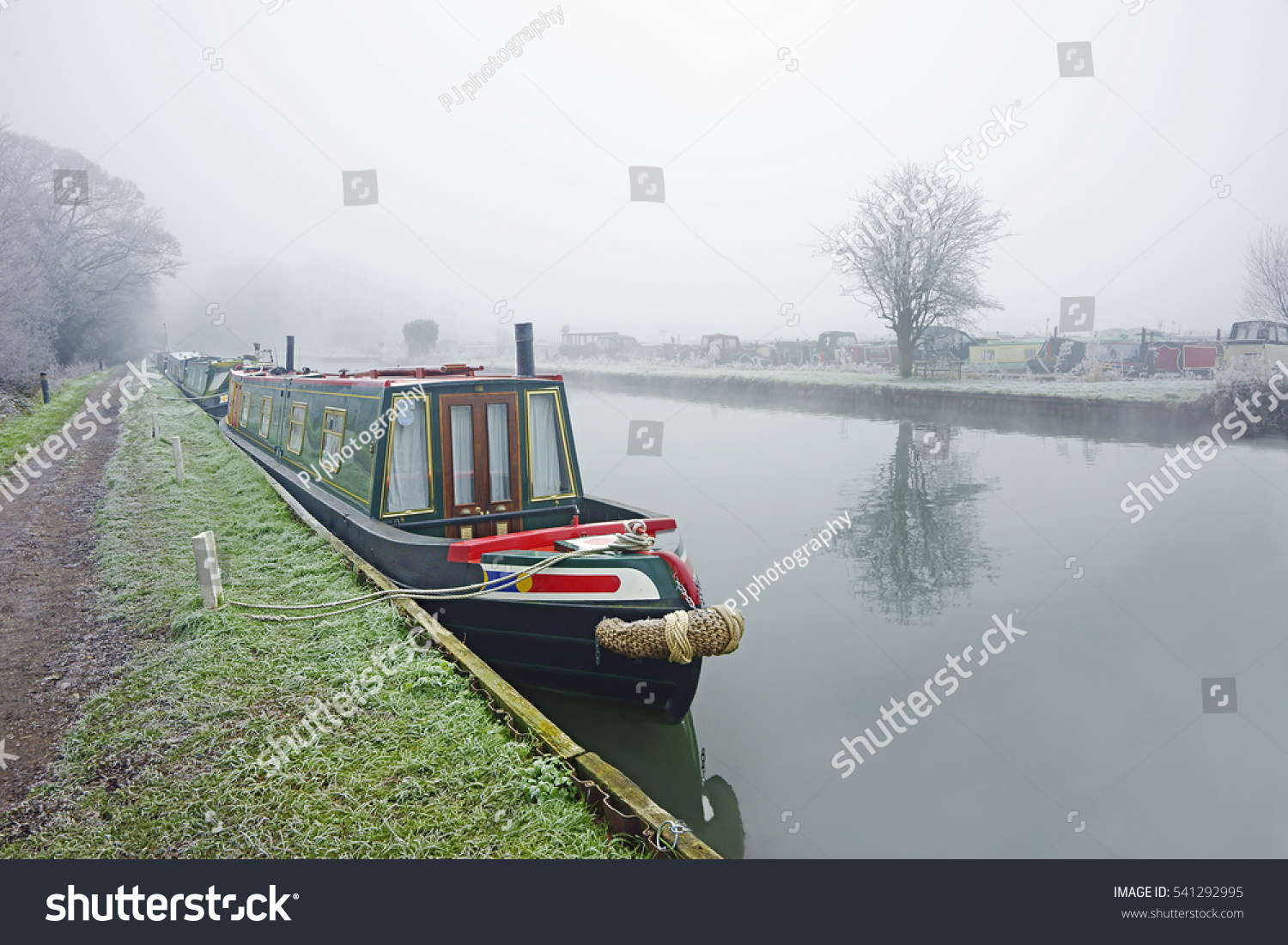 A very grey, foggy, frosty and misty early morning winter day with colourful canal barges on the Gloucester to Sharpness canal, Saul, Gloucestershire, England, United Kingdom
 #541292995