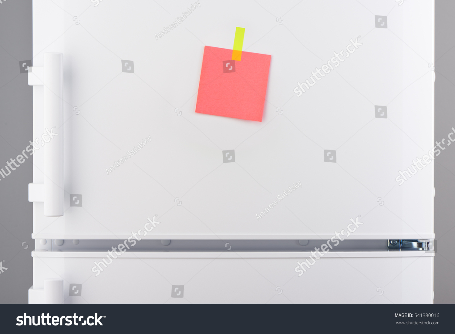Blank pink paper note attached with yellow sticker on white refrigerator door #541380016